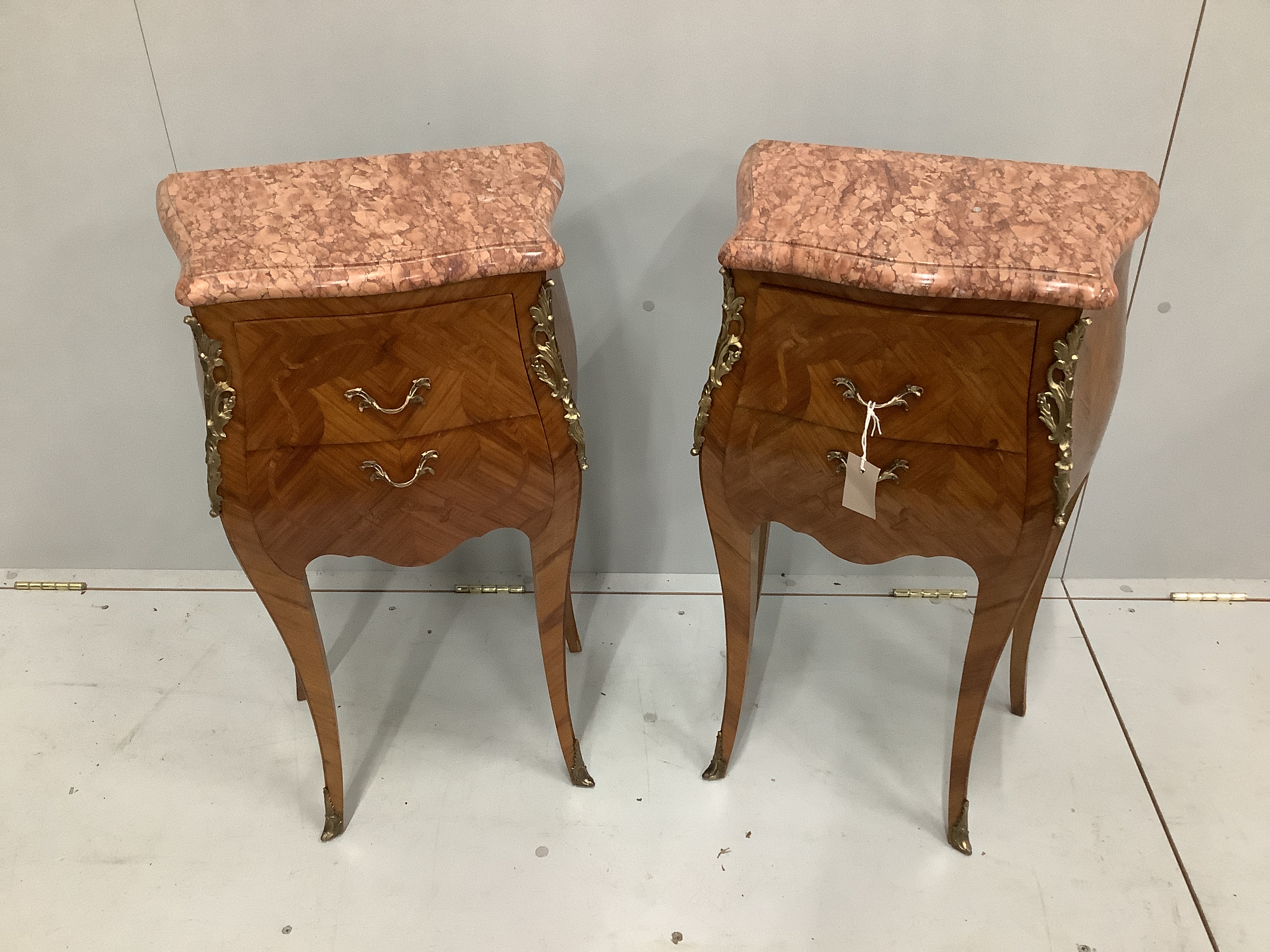 A pair of Louis XVI style gilt metal mounted inlaid kingwood marble topped bombe bedside chests, width 42cm, depth 29cm, height 73cm